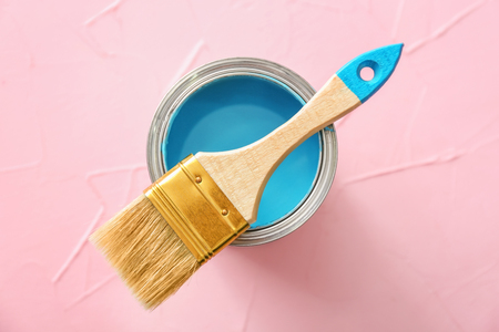 Can with blue paint and brush on color backgroundの写真素材