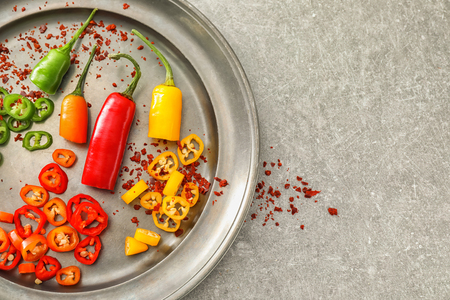 Plate with fresh and dried chili peppers on grey backgroundの写真素材