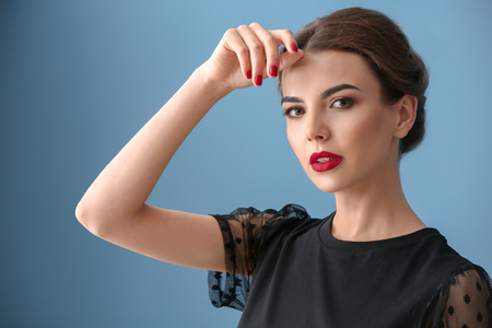 Young woman with beautiful manicure on color backgroundの写真素材