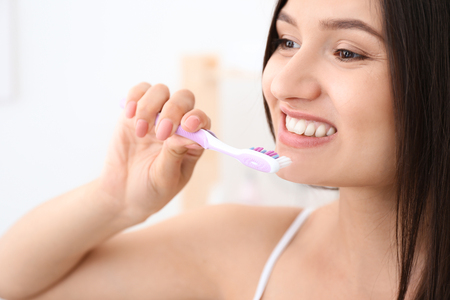 Young woman brushing her teeth in bathroomの写真素材
