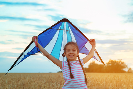 Cute little girl with kite in fieldの写真素材