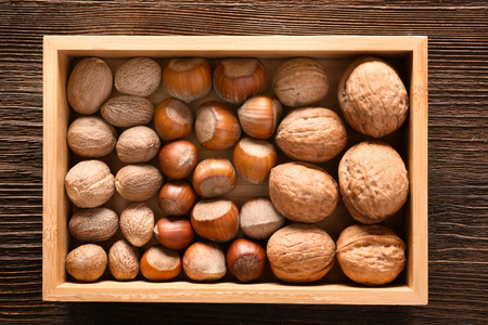 Wooden box with various nuts on table, top viewの写真素材