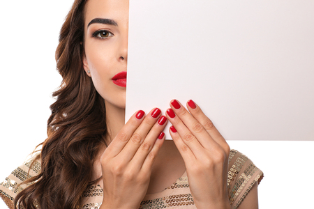 Young woman with beautiful manicure and blank poster on white backgroundの写真素材