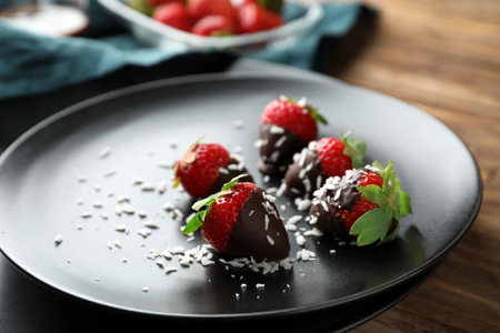 Fresh ripe strawberries covered with chocolate on plateの写真素材