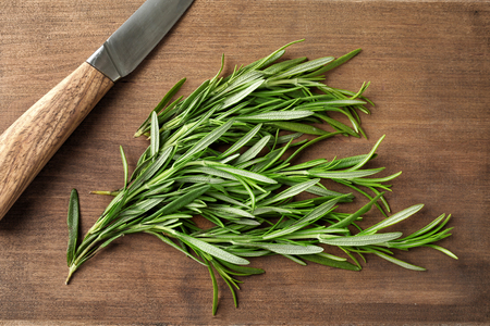 Fresh rosemary with knife on wooden boardの写真素材