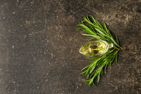 Gravy boat with oil and fresh rosemary on grey backgroundの写真素材