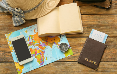 Composition with world map, compass and passport on wooden background. Travel planning