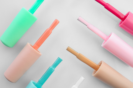Brushes with colorful nail polishes on white backgroundの写真素材