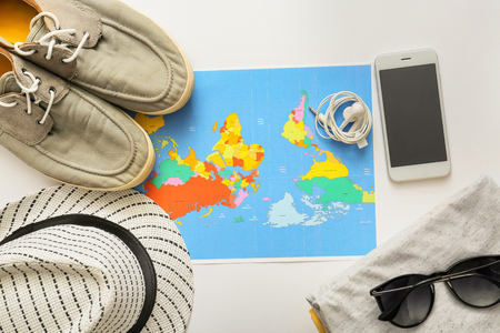 Composition with world map, mobile phone, clothes and accessories on white background. Travel planningの写真素材