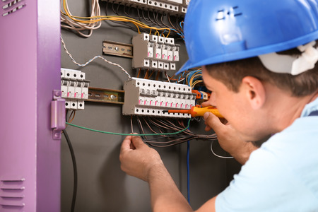 Electrician repairing distribution board indoors