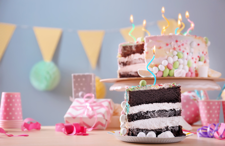 Plate with piece of tasty birthday cake on tableの写真素材