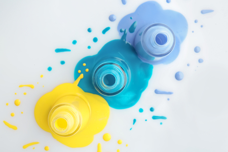 Open bottles of nail polishes on white backgroundの写真素材