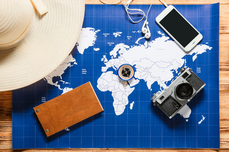 Composition with world map, photo camera and hat on wooden background. Travel planningの写真素材