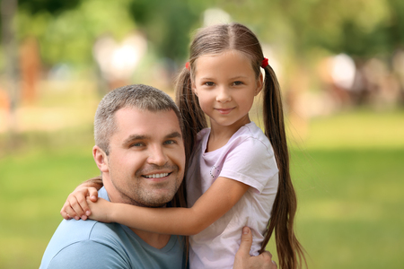 Happy father and daughter in green parkの写真素材
