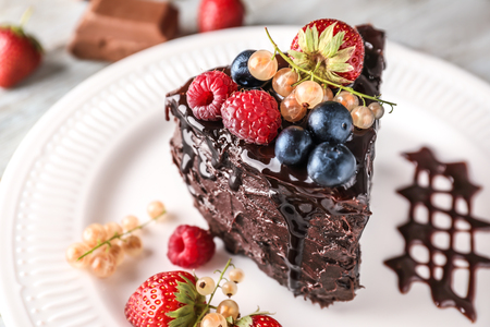 Piece of delicious chocolate cake with berries on plate, closeupの写真素材
