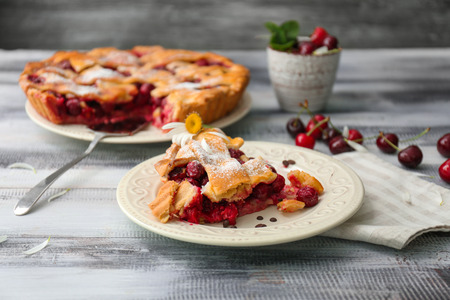 Plate with piece of delicious cherry pie on wooden tableの写真素材