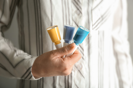 Woman holding bottles of colorful nail polishes, closeupの写真素材