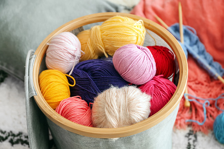 Colorful knitting yarn in basket on floor