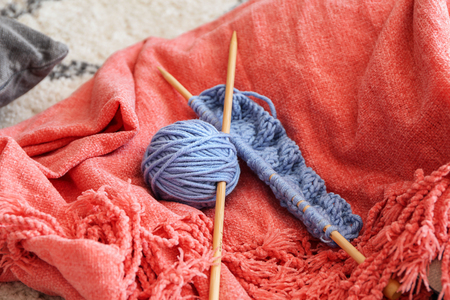 Knitting yarn with unfinished clothes on soft plaidの写真素材