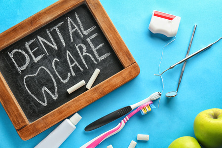 Composition with blackboard and dental hygiene equipment on color background. Healthy teeth conceptの写真素材