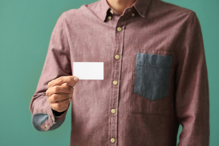 Man with business card on color background, closeupの写真素材