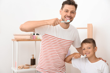 Little boy and his father brushing teeth in bathroomの写真素材