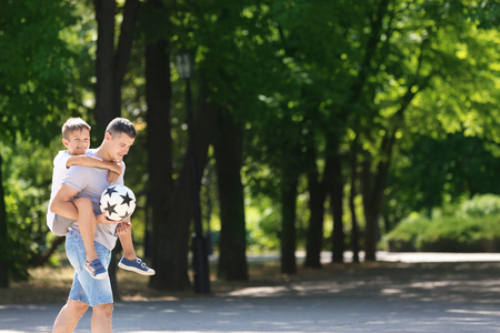 Little boy and his dad with soccer ball outdoorsの写真素材
