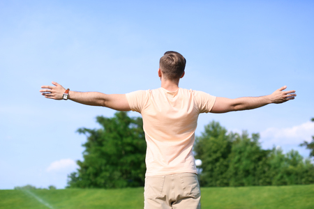 Young man resting in park on sunny dayの写真素材