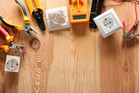 Different electrician's tools and supplies on wooden backgroundの写真素材