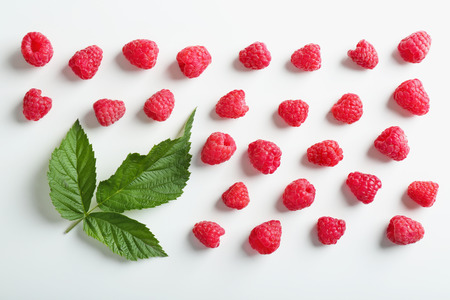 Delicious ripe raspberries with leaves on white background, top viewの写真素材