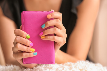 Young woman with colorful manicure holding notebook, closeupの写真素材