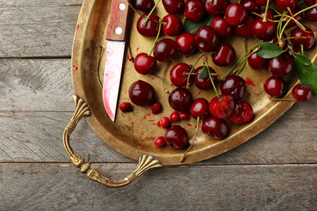 Metal tray with ripe cherries on wooden tableの写真素材
