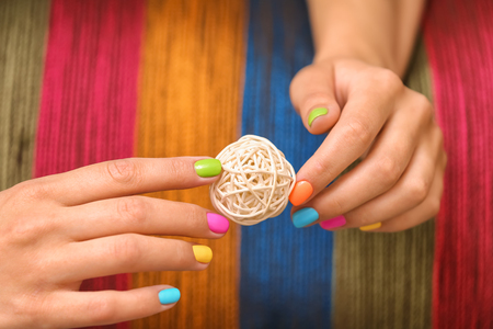 Young woman with colorful manicure holding decorative ball, closeupの写真素材