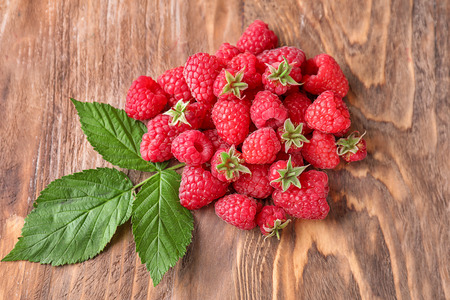Ripe aromatic raspberries on wooden background