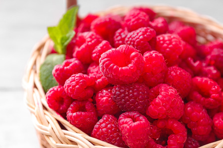 Wicker basket with fresh raspberries, closeup