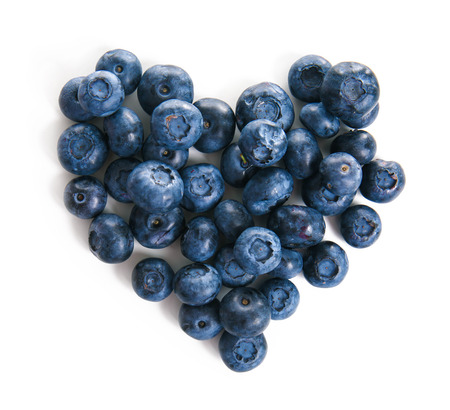 Heart made of ripe blueberries on white backgroundの写真素材