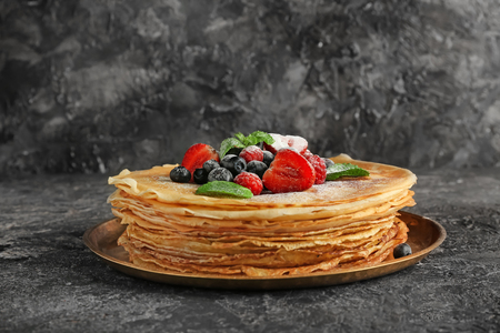 Plate with tasty pancakes and berries on grunge backgroundの写真素材
