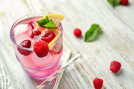 Glass of fresh raspberry mojito on wooden tableの写真素材