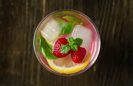 Glass of fresh raspberry mojito on wooden tableの写真素材