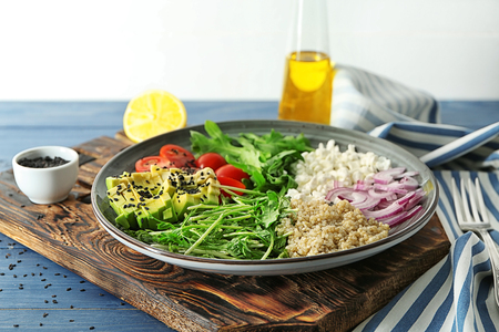 Plate with delicious healthy fresh salad on wooden boardの写真素材