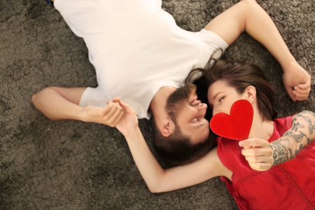 Happy lovely couple lying on floor at homeの写真素材