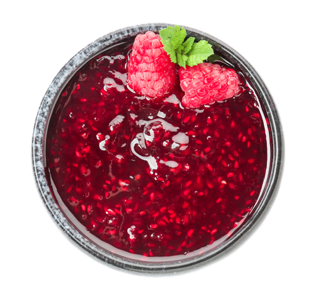 Bowl with raspberry jam on white background