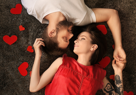 Happy lovely couple lying on floor at homeの写真素材