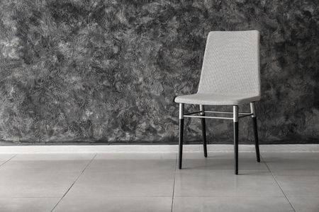 Comfortable chair near dark wallの写真素材