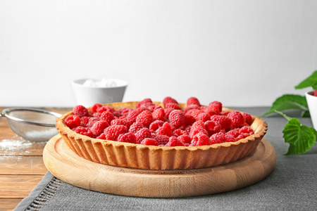 Tasty pie with fresh raspberries on tableの写真素材