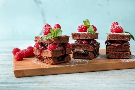 Delicious cakes with raspberries on wooden boardの写真素材