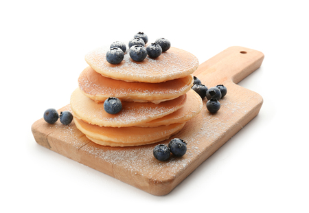 Board with delicious pancakes and berries on white backgroundの写真素材