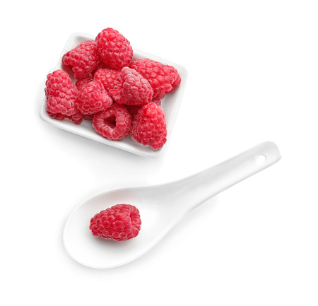 Bowl and spoon with sweet ripe raspberries on white backgroundの写真素材