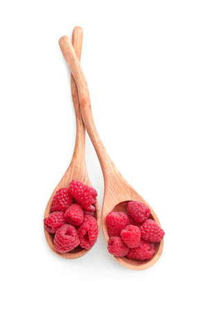 Wooden spoons with sweet ripe raspberries on white backgroundの写真素材