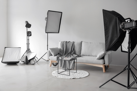 Cozy sofa and table in photo studio with professional equipmentの写真素材